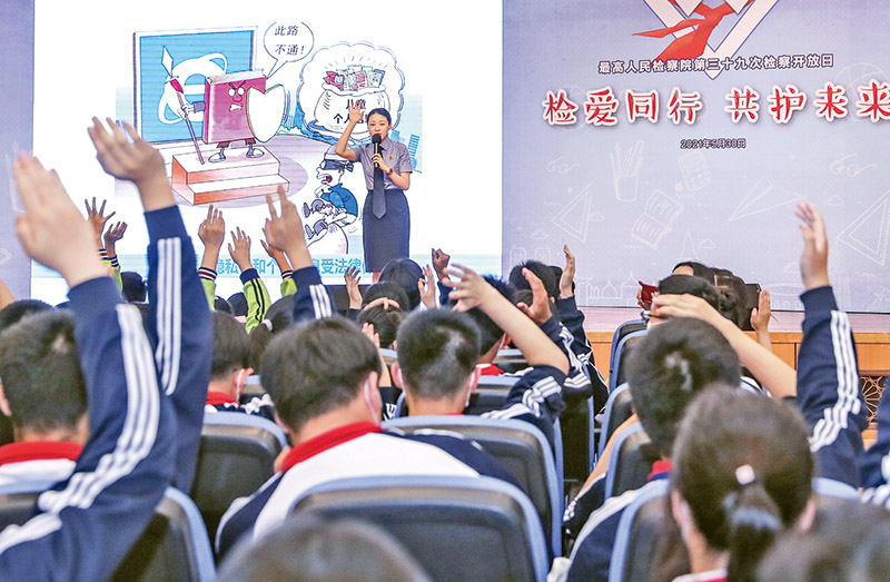 2021年5月30日,在新修订的未成年人保护法和预防未成年人犯罪法即将正式施行之际,最高人民检察院举办以“检爱同行 共护未来”为主题的检察开放日活动。图为在开放日活动的法治教育课上,工作人员与学生互动。 新华社记者 殷刚/摄