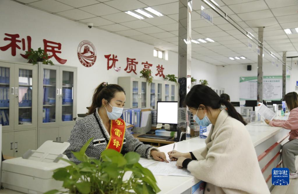 河北省邢台市襄都区宴家屯镇综合服务中心工作人员协助办事群众填写相关表格(2022年3月30日摄)。